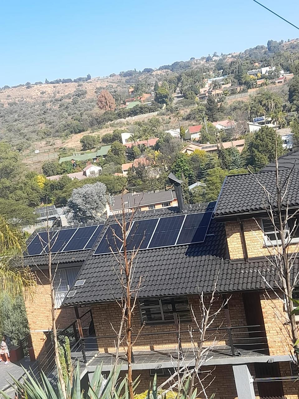 A Sun Savings array installed on a tiled roof with mountains behind it